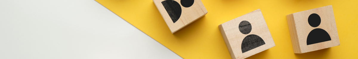 Three wooden blocks with outline of people drawn on them. 